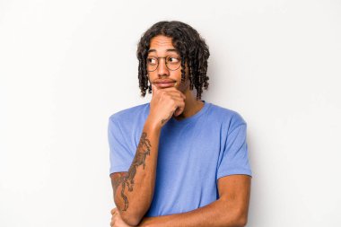 Beyaz arka planda izole edilmiş genç Afrikalı Amerikalı adam kafası karışmış, şüpheli ve güvensiz hissediyor..