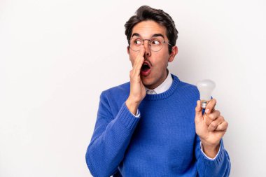 Beyaz arka planda izole edilmiş bir ampul tutan genç beyaz bir adam gizli bir fren haberinin olduğunu söylüyor.