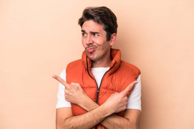 Beyazların arka plan noktalarında izole edilmiş genç beyaz adam iki seçenek arasında seçim yapmaya çalışıyor..