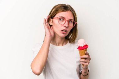 Beyaz arka planda izole edilmiş dondurma tutan genç İngiliz kadın bir dedikoduyu dinlemeye çalışıyor..