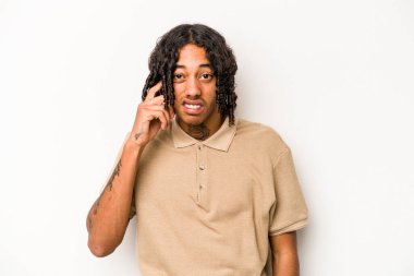 Genç Afrikalı Amerikalı bir adam beyaz arka planda izole edilmiş parmaklarıyla kulaklarını kapatan, yüksek sesli bir ortam tarafından stresli ve umutsuz..