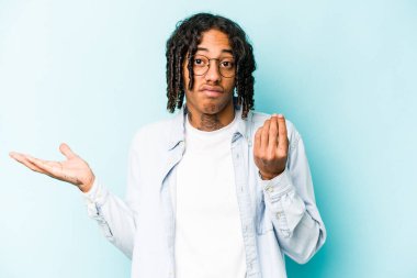 Genç Afrikalı Amerikalı bir adam mavi arka planda izole edilmiş. Bu da parasız olduğunu gösteriyor..