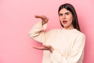 Pembe arka planda izole edilmiş genç beyaz kadın elleri arasında bir kopya alanı tutarken şok ve hayrete düştü..