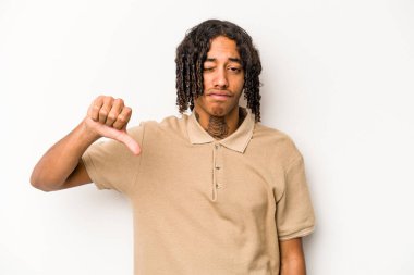 Beyaz arka planda izole edilmiş genç Afro-Amerikan adam baş parmağını aşağı gösteriyor, hayal kırıklığı konsepti.