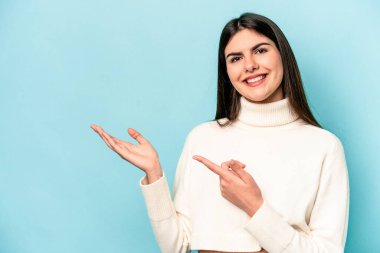 Mavi arka planda izole edilmiş beyaz bir kadın. Elinde palmiye ağacının fotokopisini tutarken heyecanlı..