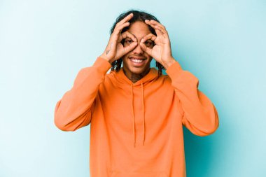 Genç Afrikalı Amerikalı bir adam mavi arka planda izole edilmiş. Heyecanlı..