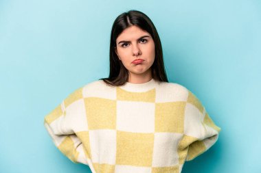 Genç beyaz kadın mavi arka planda izole edilmiş üzgün, ciddi yüzlü, mutsuz ve hoşnutsuz..