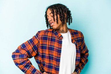 Genç Afrikalı Amerikalı adam mavi arka planda izole edilmiş sırt ağrısı çekiyor..