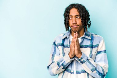 Genç Afro-Amerikalı adam mavi arka planda izole edildi. Aklında bir plan oluşturdu..
