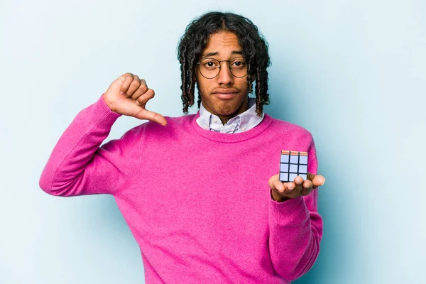 Jovem Afro Americano Segurando Cubo Rubiks Isolado Fundo Azul Sente — Fotografia de Stock