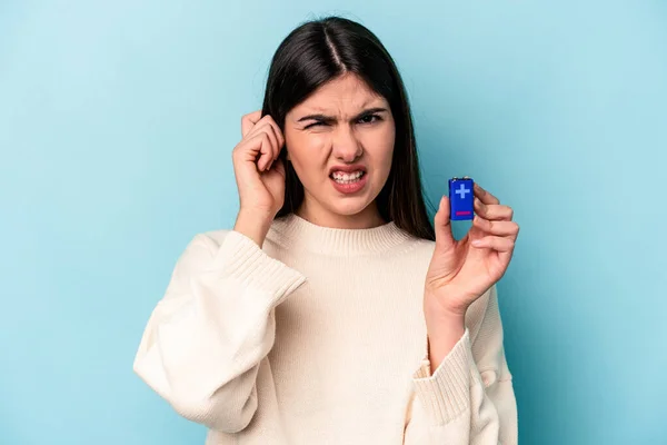 Young Caucasian Woman Holding Batterie Isolated Blue Background Covering Ears — Stock Photo, Image