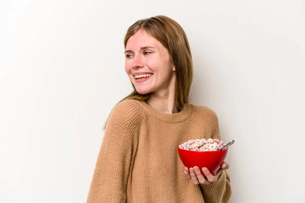年轻的英国女人吃着孤立在白色背景下的谷类食品 面带微笑 快乐而愉快 — 图库照片