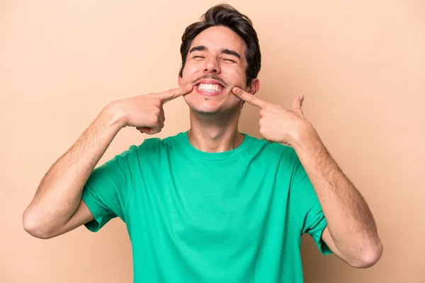 Jonge Blanke Man Geïsoleerd Beige Achtergrond Glimlacht Wijzende Vingers Naar — Stockfoto