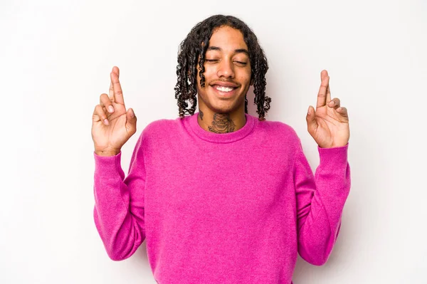 Genç Afrikalı Amerikalı adam beyaz arka planda izole edilmiş şans diliyor.