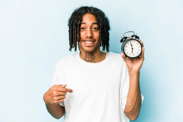 Jovem Afro Americano Segurando Despertador Isolado Fundo Azul Pessoa Apontando — Fotografia de Stock