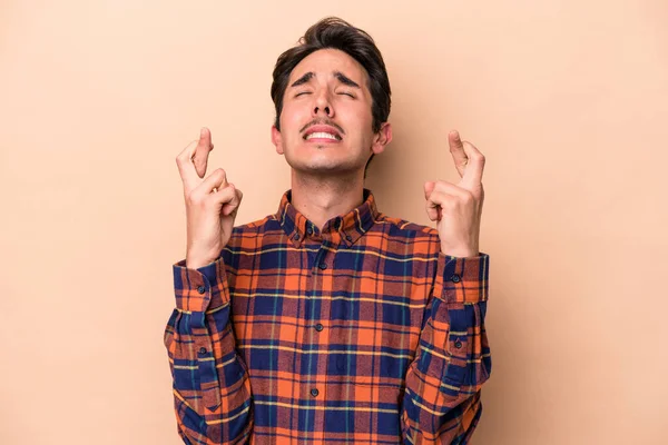 Young Caucasian Man Isolated Beige Background Crossing Fingers Having Luck — Stock Photo, Image