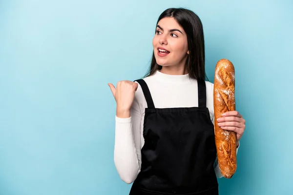 年轻的面包师拿着一块面包 夹在蓝色的背景点上 无忧无虑 无忧无虑 无忧无虑 无忧无虑地笑着 — 图库照片