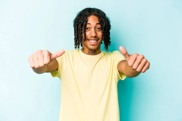 아프리카 미국인 남자파란 배경에 고립되어 웃으며 손가락을 치켜올리고 자신감 — 스톡 사진