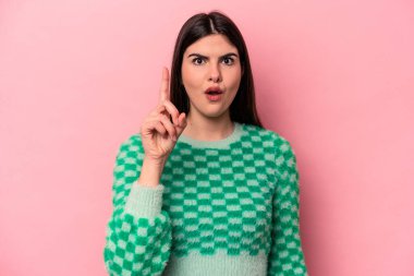 Pembe arka planda izole edilmiş beyaz bir kadın ağzı açık bir şekilde üst tarafı işaret ediyor..