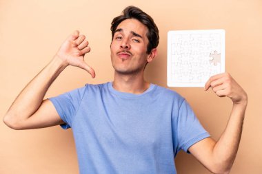 Beyazların arka planında yapboz tutan genç beyaz adam gururlu ve kendinden emin hissediyor, örnek olarak..