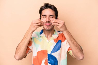 Beyazlı genç bir adam bej arka planda iki seçenek arasında kuşkulanıyor..