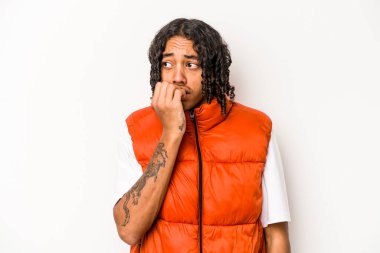 Genç Afrikalı Amerikalı bir adam beyaz arka planda izole edilmiş tırnak yiyor, gergin ve endişeli..