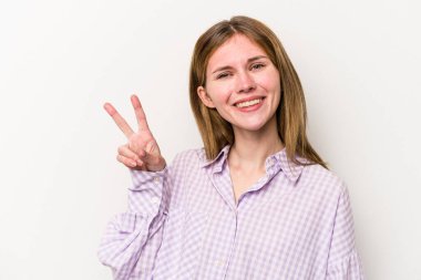 Beyaz arka planda izole edilmiş genç bir Rus kadın zafer işareti gösteriyor ve gülümsüyor..