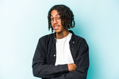 Genç Afrikalı Amerikalı adam mavi arka planda izole edilmiş mutlu, güler yüzlü ve neşeli..