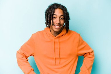 Genç Afrikalı Amerikalı adam mavi arka planda izole edilmiş mutlu, güler yüzlü ve neşeli..