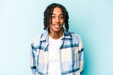 Genç Afrikalı Amerikalı adam mavi arka planda izole edilmiş mutlu, güler yüzlü ve neşeli..