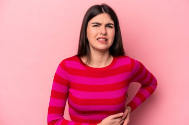 Pembe arka planda karaciğer ağrısı çeken, karnı ağrıyan beyaz bir kadın..