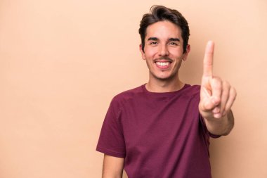 Beyazlı genç bir adam bej arka planda izole edilmiş. Parmak izi 1 numara..