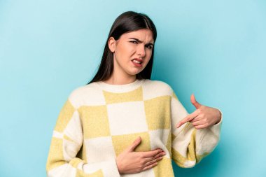 Mavi arka planda karaciğer ağrısı çeken, karnı ağrıyan beyaz bir kadın..