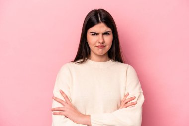 Pembe arka planda soyutlanmış beyaz bir kadın hoşnutsuzca kaşlarını çatmış, kollarını kavuşturmuş..