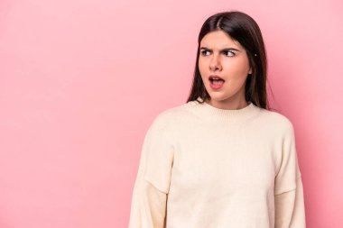 Pembe arka planda izole edilmiş beyaz bir kadın gördüğü bir şey yüzünden şoka uğruyor..