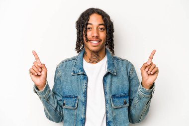Beyaz arka planda izole edilmiş genç Afrikalı Amerikalı iki parmağı da boş bir alan gösteriyor..