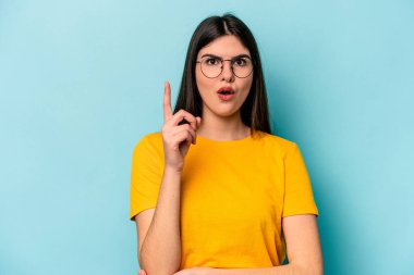 Kafkasyalı genç bir kadın mavi arka planda izole edilmiş. Harika bir fikri var, yaratıcılık kavramı..