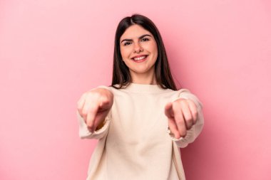 Pembe arka planda soyutlanmış beyaz bir kadın. Önü işaret eden neşeli gülümsemeler..