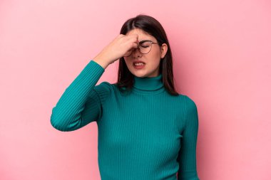 Pembe arka planda soyutlanmış, başı ağrıyan, yüzüne dokunan beyaz bir kadın..