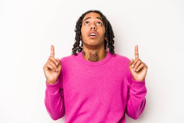 Beyaz arka planda izole edilmiş genç Afro-Amerikalı adam ağzı açık bir şekilde üst tarafı işaret ediyor..