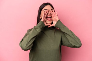 Pembe arka planda izole edilmiş beyaz bir kadın heyecanlı bir şekilde bağırıyor..