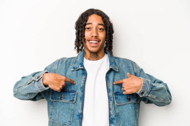 Beyaz arka planda izole edilmiş genç bir Afro-Amerikan erkeği parmağını gösterip gülümseyerek şaşırdı..
