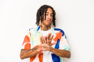 Beyaz arka planda izole edilmiş genç Afrikalı Amerikalı bir adam inkar jesti yapıyor.