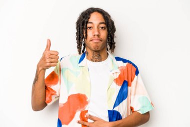 Beyaz arka planda izole edilmiş genç Afrikalı Amerikalı adam karnına dokunuyor, nazikçe gülümsüyor, yemek yiyor ve tatmin oluyor..