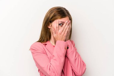 Beyaz arka planda izole edilmiş genç bir Rus kadın parmaklarının arasından korkmuş ve gergin bir şekilde göz kırpıyor..