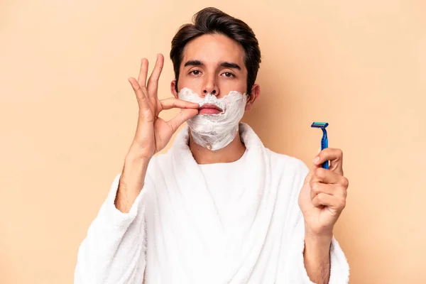 Young Caucasian Man Shaving His Beard Isolated Beige Background Fingers — Stock Photo, Image