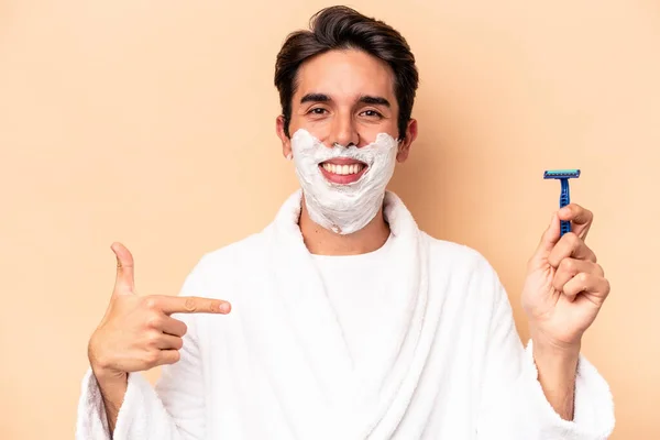 Young Caucasian Man Shaving His Beard Isolated Beige Background Person — Stock Photo, Image