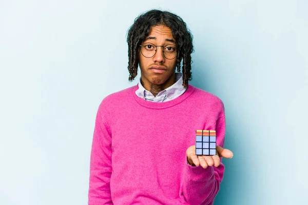 Jovem Afro Americano Segurando Cubo Rubiks Isolado Fundo Azul Encolhe — Fotografia de Stock