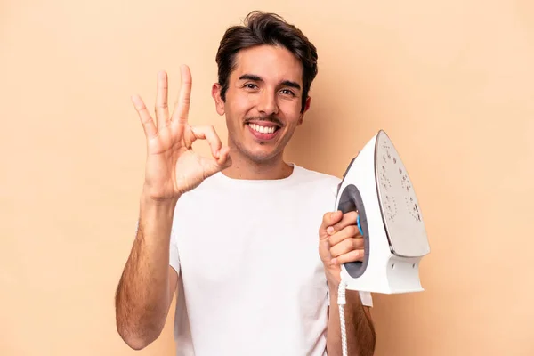Young Caucasian Man Holding Iron Isolated Beige Background Cheerful Confident — Stock Photo, Image