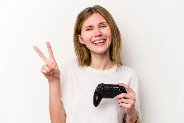 年轻的英国女人和一个视频游戏控制器玩孤立的白色背景 用手指显示二号 — 图库照片